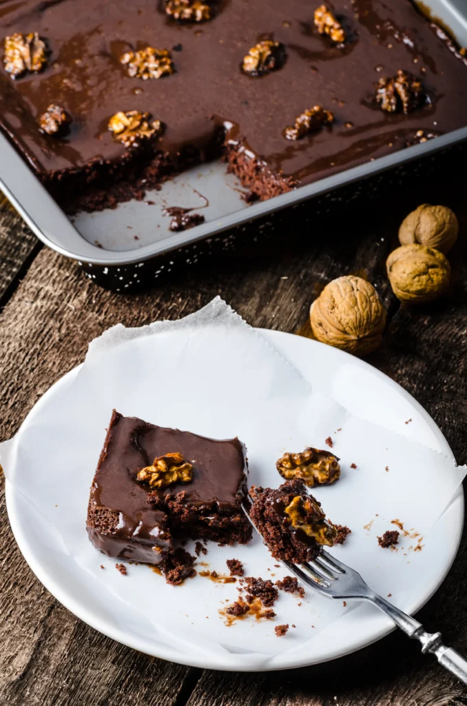 Traditional Texas Sheet Cake
Freshly baked Texas Sheet Cake topped with rich chocolate frosting and chopped pecans on a rustic kitchen table