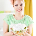 Creamy homemade grape salad with red and green grapes, topped with brown sugar and chopped pecans in a bowl