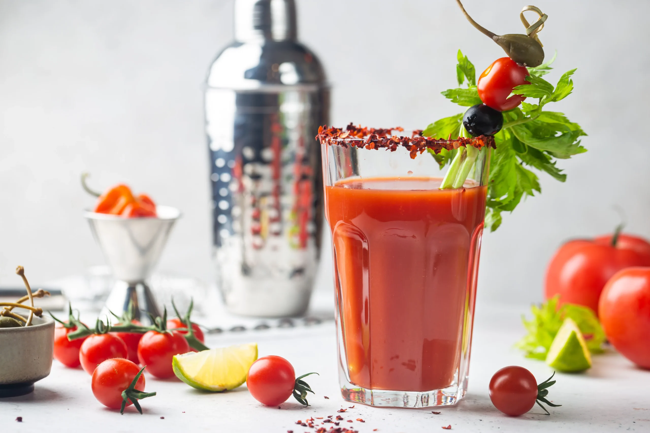 Flavor-packed Bloody Mary cocktail garnished with celery, lemon, olives, and spices in a tall glass.