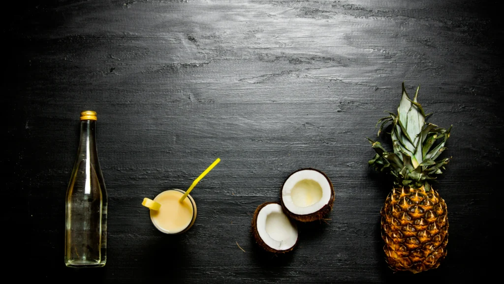 Creamy tropical pina colada cocktail served in a chilled glass with pineapple slices, coconut flakes, and cherries on a summer beach-themed table