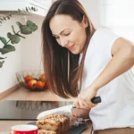 Freshly baked chocolate chip banana bread sliced on a wooden board, filled with melted chocolate chips and made with ripe bananas, perfect for beginner bakers.