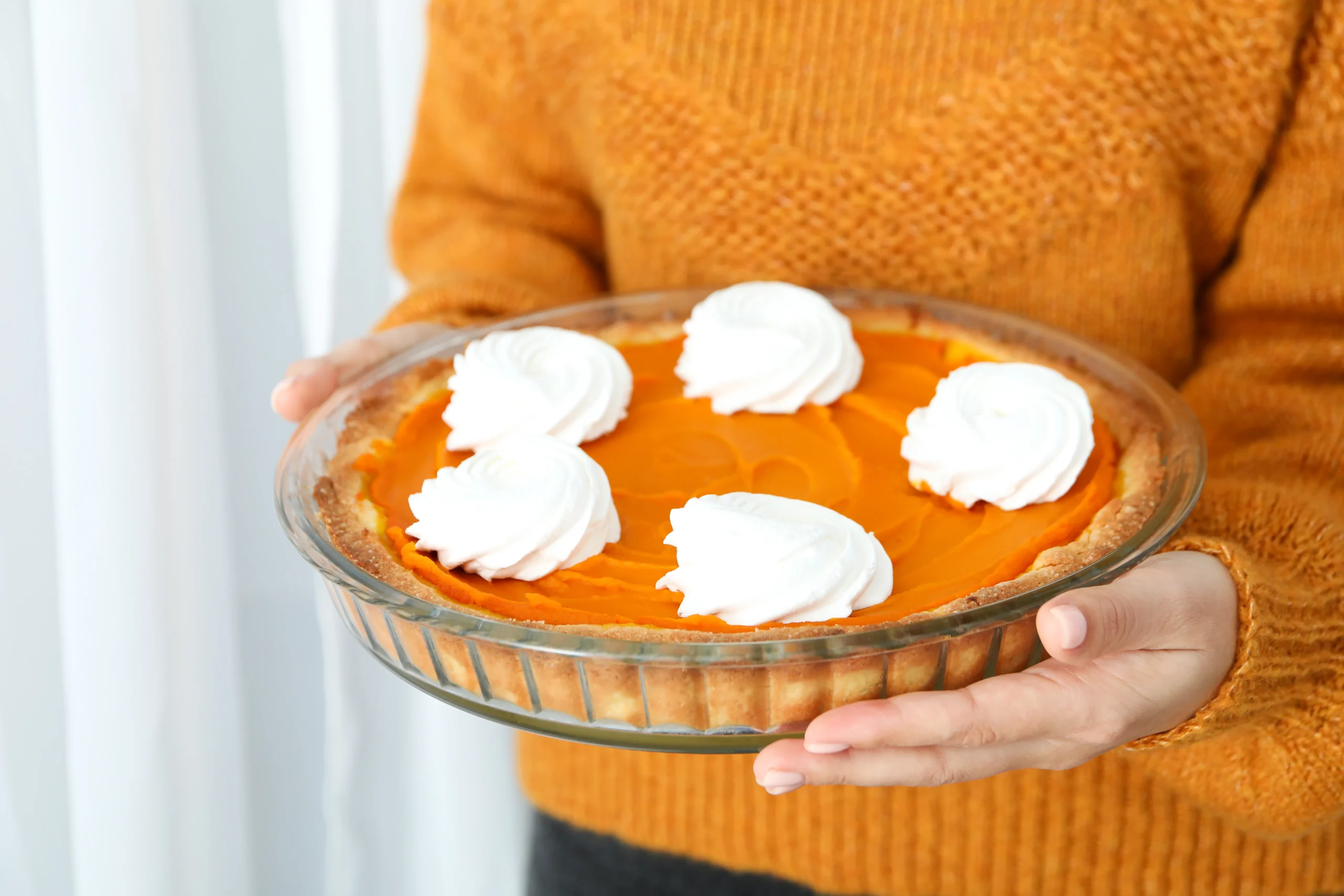Classic Libby’s pumpkin pie topped with whipped cream on a wooden table during the holiday season