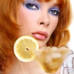 A chilled lemon drop martini served in a sugar-rimmed cocktail glass with fresh lemon slices and a bright yellow cocktail on a modern bar counter.