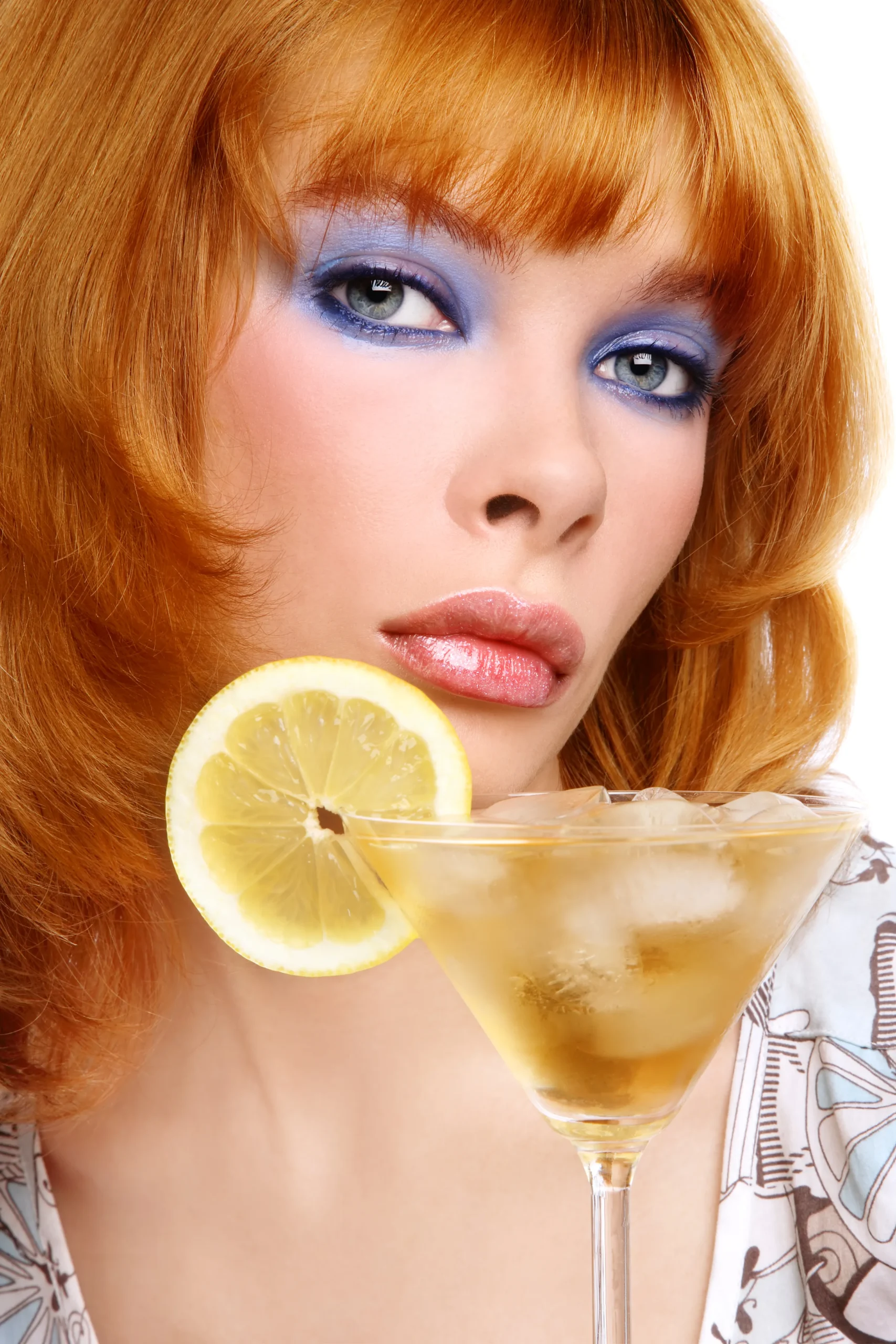 A chilled lemon drop martini served in a sugar-rimmed cocktail glass with fresh lemon slices and a bright yellow cocktail on a modern bar counter.