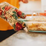 Fresh peach cobbler baked to golden perfection in a rustic dish, featuring juicy sliced peaches beneath a buttery, crisp topping, served warm with a scoop of vanilla ice cream on a sunny summer day.
