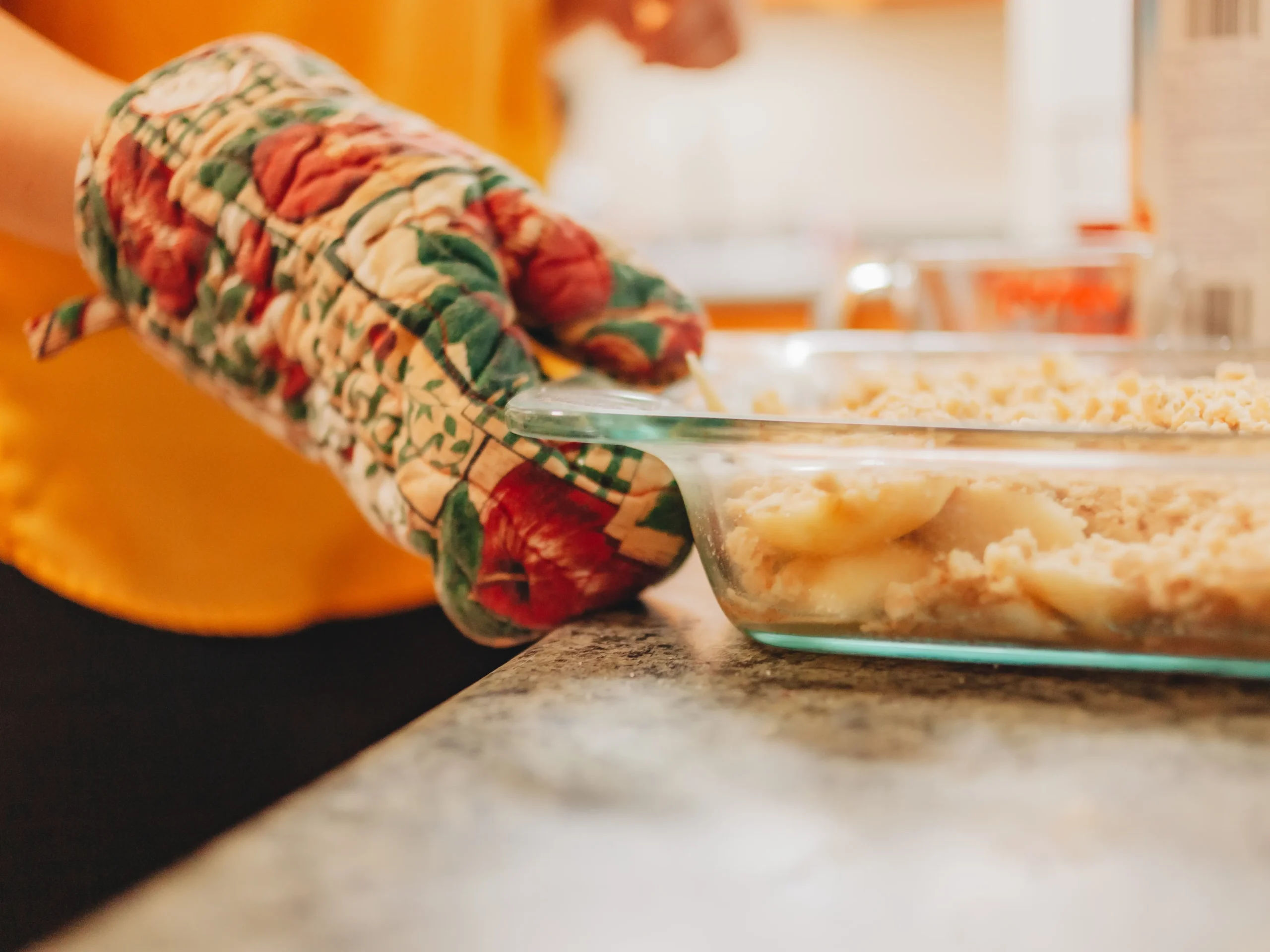Fresh peach cobbler baked to golden perfection in a rustic dish, featuring juicy sliced peaches beneath a buttery, crisp topping, served warm with a scoop of vanilla ice cream on a sunny summer day.