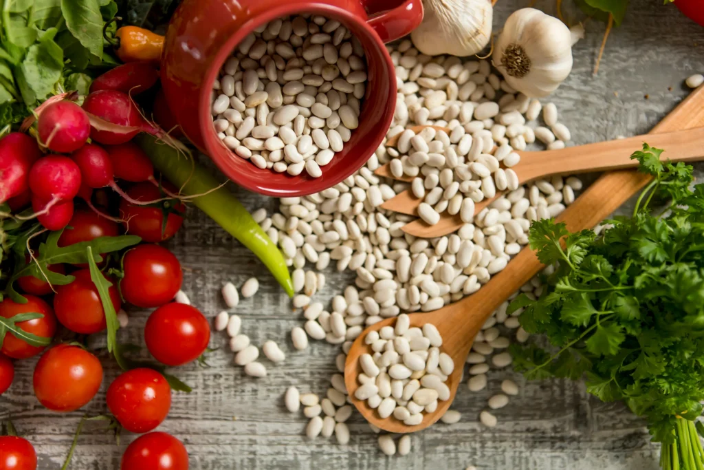 A rustic bowl of Tuscan white bean soup with cannellini beans, kale, carrots, and herbs served warm on a wooden table