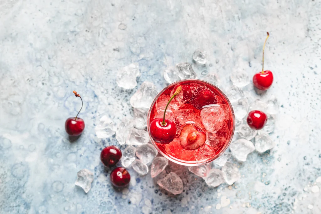 A refreshing glass of Shirley Temple made with just three ingredients, garnished with bright red maraschino cherries and served over ice for a classic, family-friendly mocktail.
