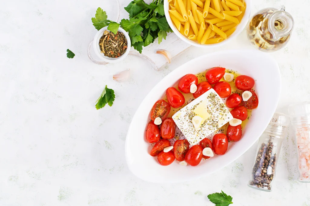 Fresh Tomato & Feta Pasta Salad made with rotini pasta, cherry tomatoes, crumbled feta cheese, cucumber, basil, and a lemon olive oil dressing in a serving bowl.