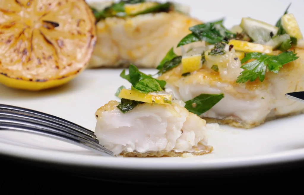 Sea Bass Recipe
Oven-baked Chilean sea bass with garlic and fresh herbs on a white plate