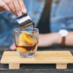 Carajillo recipe with espresso and Licor 43 served in a glass with coffee beans and cinnamon sticks