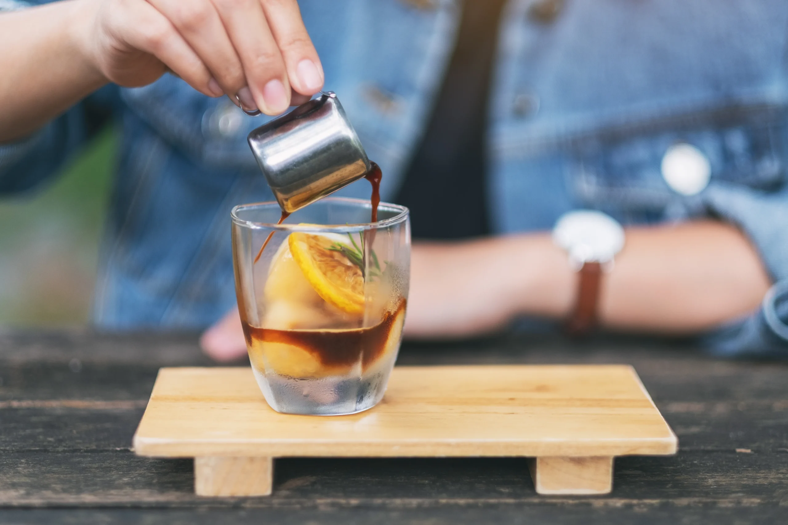 Carajillo recipe with espresso and Licor 43 served in a glass with coffee beans and cinnamon sticks