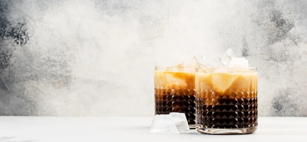 Carajillo recipe with espresso and Licor 43 served in a glass with coffee beans and cinnamon sticks