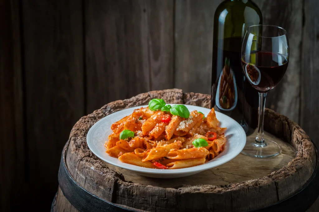 Creamy Penne alla Vodka pasta served in a bowl with rich tomato cream sauce, Parmesan cheese, and fresh basil garnish.