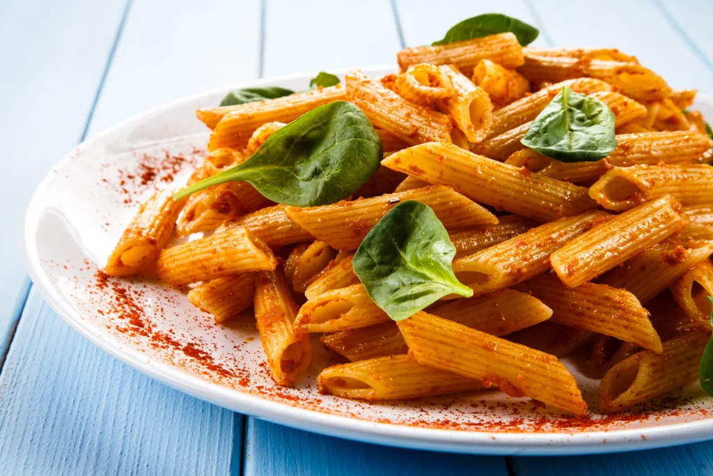Creamy Penne alla Vodka pasta served in a bowl with rich tomato cream sauce, Parmesan cheese, and fresh basil garnish.