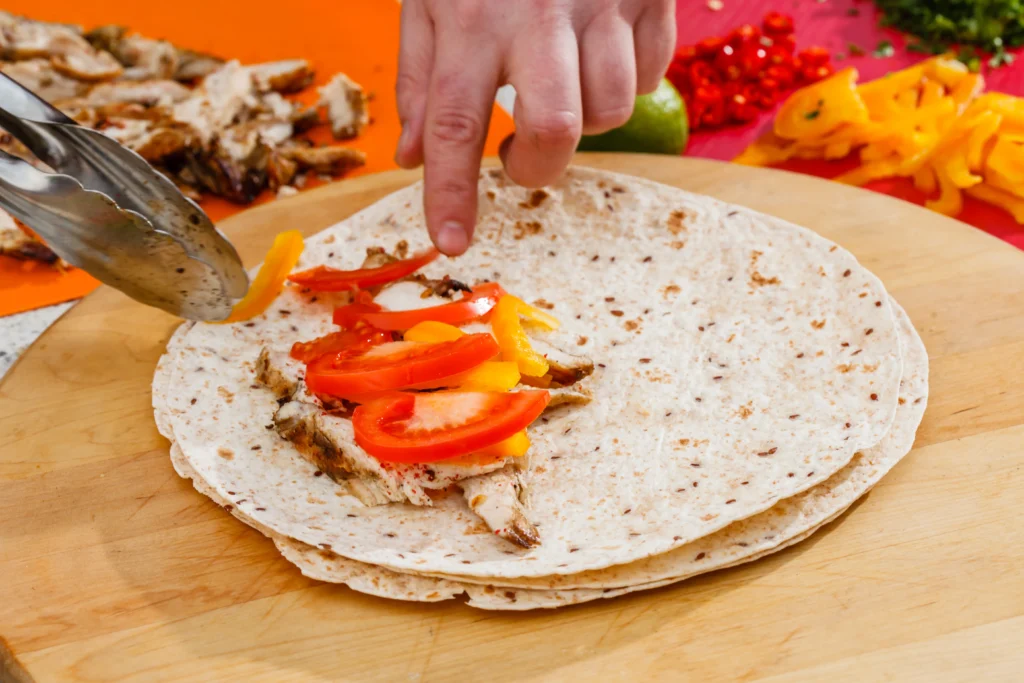 Sheet pan chicken fajitas with seasoned grilled chicken strips, colorful bell peppers, and onions roasted to perfection, served with warm tortillas and fresh lime wedges.