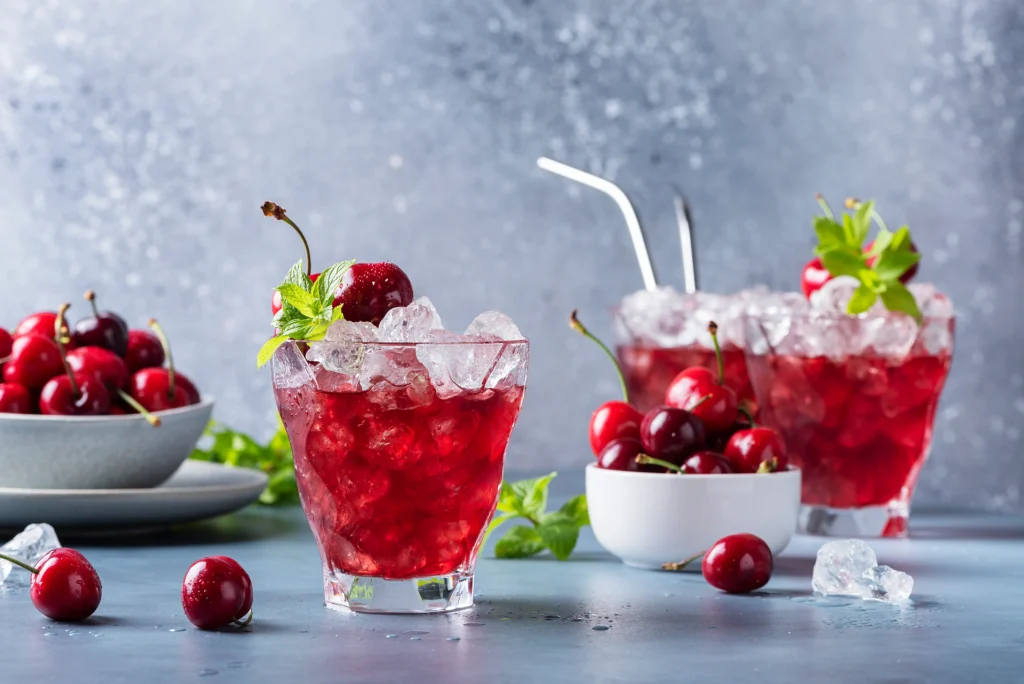 A refreshing glass of Shirley Temple made with just three ingredients, garnished with bright red maraschino cherries and served over ice for a classic, family-friendly mocktail.