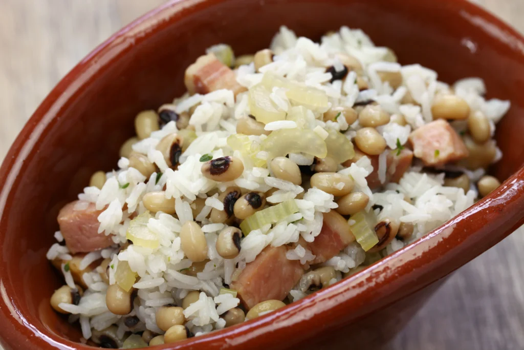 A bowl of traditional Hoppin' John made with black-eyed peas, rice, smoked sausage, and Southern seasonings, garnished with fresh herbs.