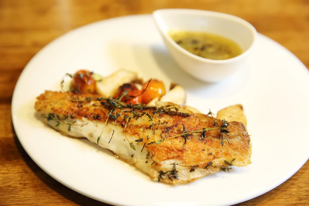 Sea Bass Recipe
Oven-baked Chilean sea bass with garlic and fresh herbs on a white plate