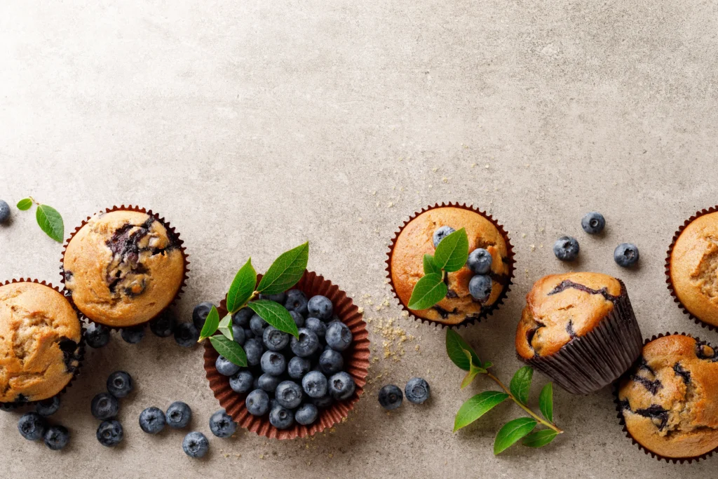 Moist homemade cottage cheese muffins served on a cooling rack with fresh blueberries, perfect for a high-protein breakfast.
