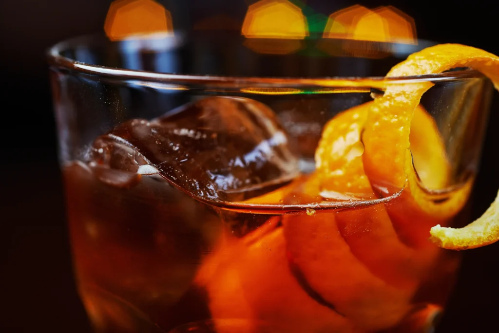 Perfect Classic Old Fashioned Cocktail Recipe with bourbon, orange peel, and ice in a whiskey glass
