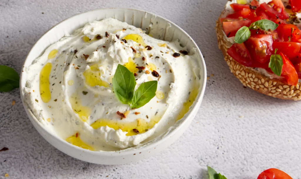 Feta Dip Recipe
A beautifully presented bowl of whipped feta dip garnished with a drizzle of extra virgin olive oil, chopped fresh parsley, oregano, cracked black pepper, and red pepper flakes. The dip is surrounded by warm pita triangles, crunchy crackers, cucumber slices, carrot sticks, and cherry tomatoes on a rustic wooden serving board. This Mediterranean-inspired appetizer is quick to prepare, packed with bold flavors, and ideal for entertaining, holiday gatherings, or healthy snacking.