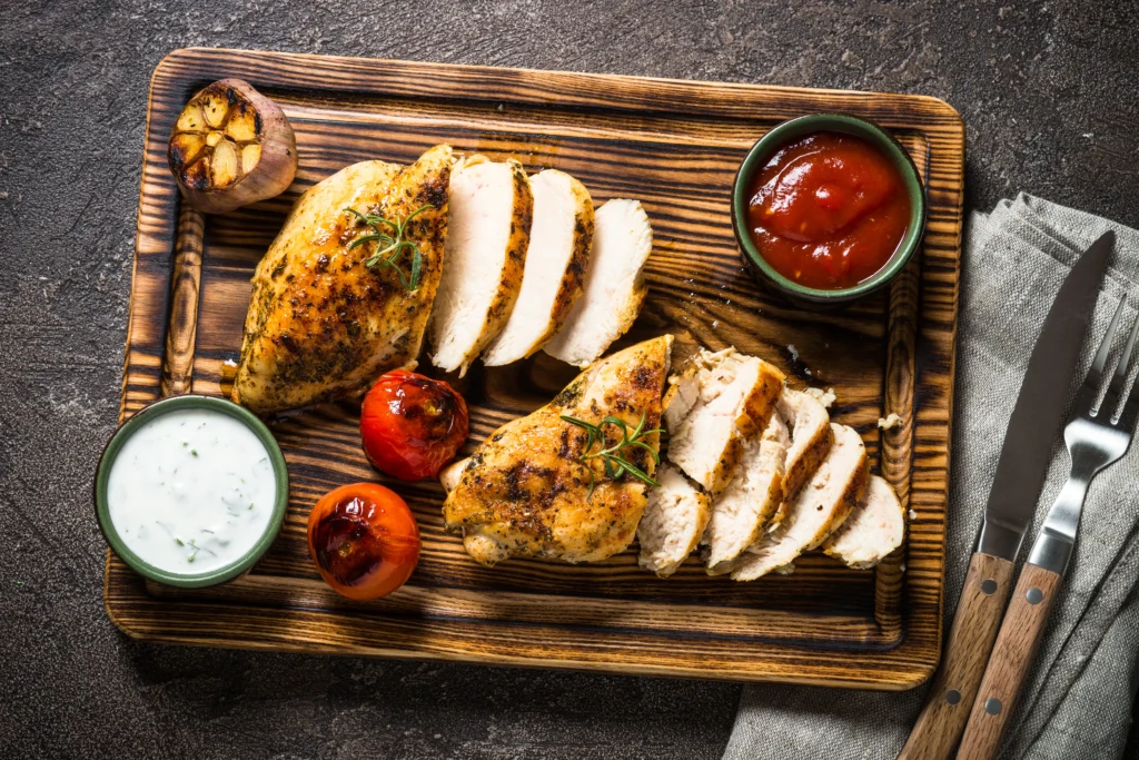 Juicy air fryer chicken breast served on a plate with roasted vegetables and fresh herbs, perfectly seasoned and cooked until golden brown.
