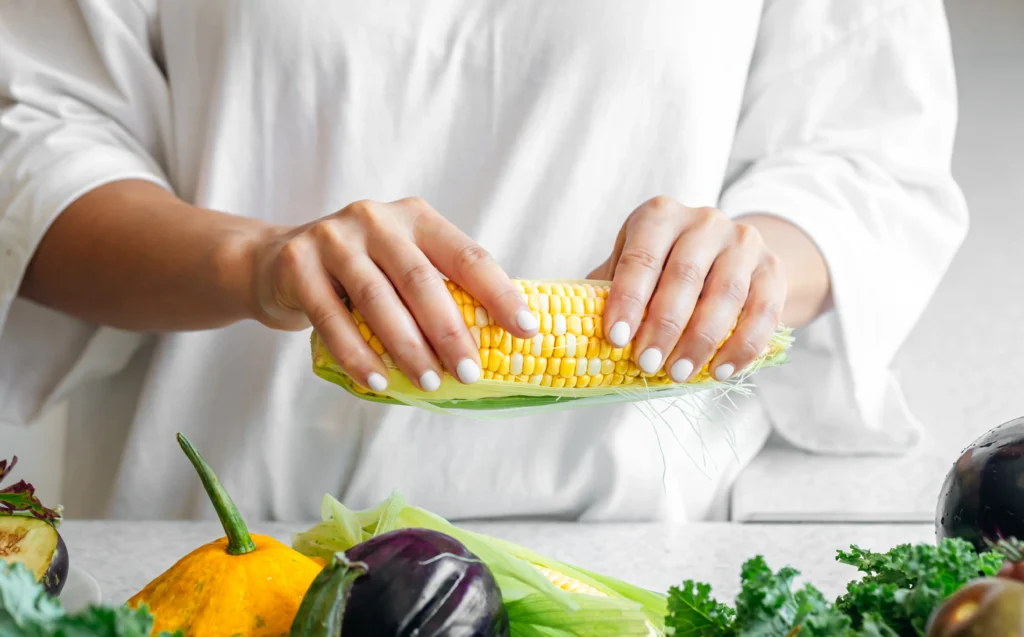 A vibrant bowl of authentic Mexican Street Corn Salad (Elote Salad) made with grilled sweet corn, cotija cheese, cilantro, lime wedges, and chili powder, served fresh in a rustic bowl.