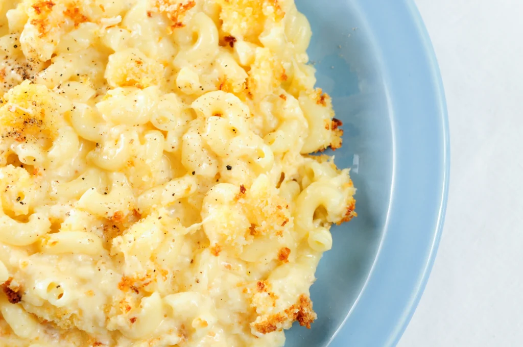 Creamy homemade mac and cheese baked until golden brown with a rich, cheesy sauce, served in a white baking dish just like Grandma's classic comfort food recipe.