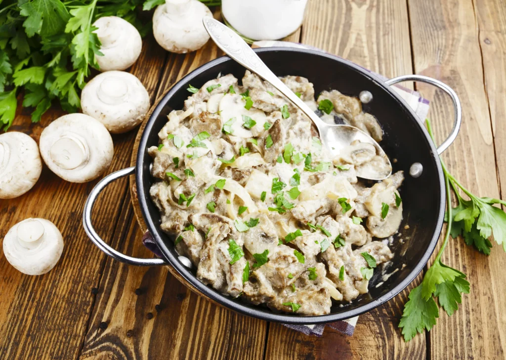 Creamy Ground Beef Stroganoff served over egg noodles with mushrooms and fresh parsley
