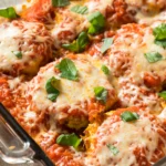 Crispy ground chicken Parmesan patties served with fresh parsley, grated Parmesan cheese, and marinara sauce on a white plate.