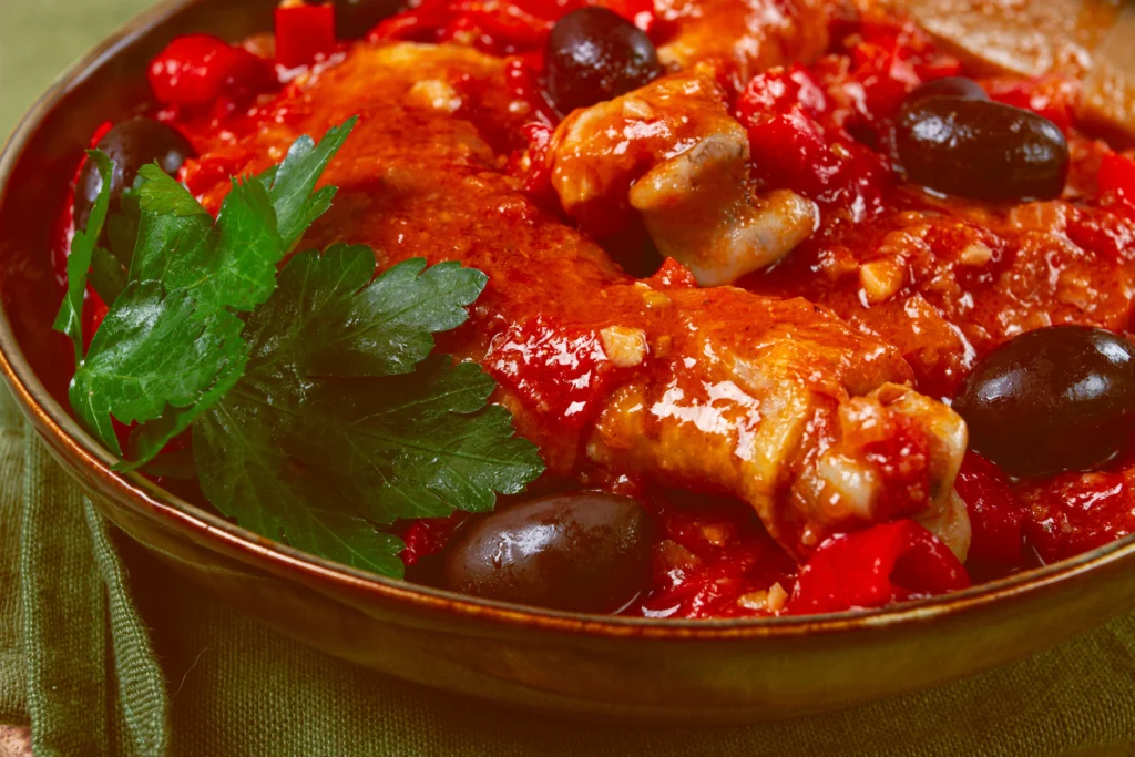 Easy Cacciatore Recipe served in a Dutch oven with tender chicken, tomatoes, mushrooms, bell peppers, onions, and fresh basil in a rich Italian tomato sauce.