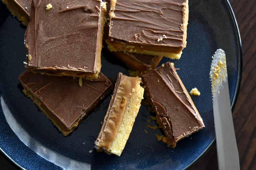 Homemade Nanaimo Bars with rich chocolate topping, creamy custard filling, and a coconut graham cracker base