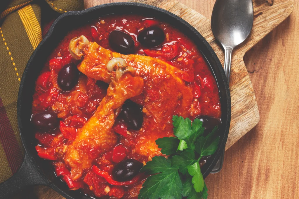 Easy Cacciatore Recipe served in a Dutch oven with tender chicken, tomatoes, mushrooms, bell peppers, onions, and fresh basil in a rich Italian tomato sauce.