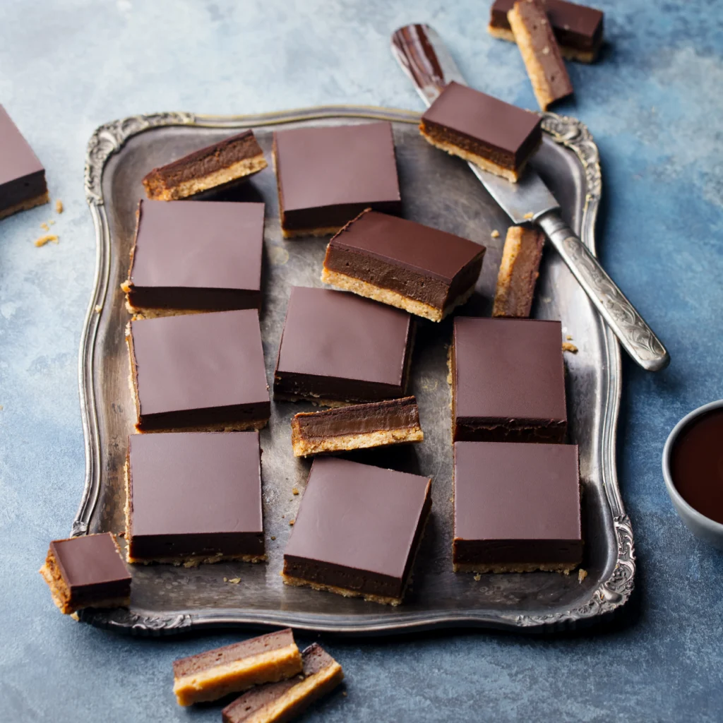 Homemade Nanaimo Bars with rich chocolate topping, creamy custard filling, and a coconut graham cracker base