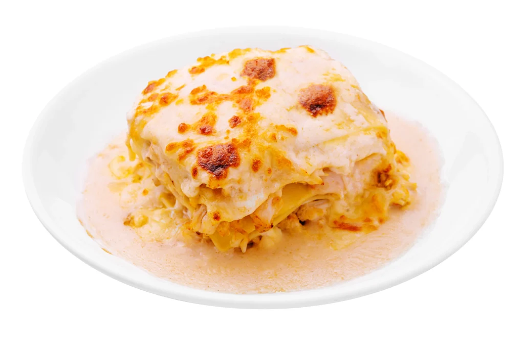 A hearty bowl of lasagna beans topped with melted mozzarella, grated Parmesan, fresh basil, and rich tomato sauce, served with crusty bread.