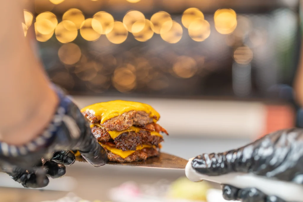 Juicy homemade smash burger with crispy beef patties, melted cheddar cheese, fresh lettuce, tomato, pickles, and a toasted brioche bun served with golden French fries.