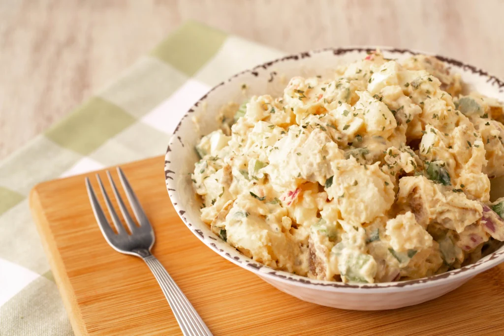 Classic American potato salad recipe with creamy dressing, boiled potatoes, eggs, and fresh vegetables served for BBQ season