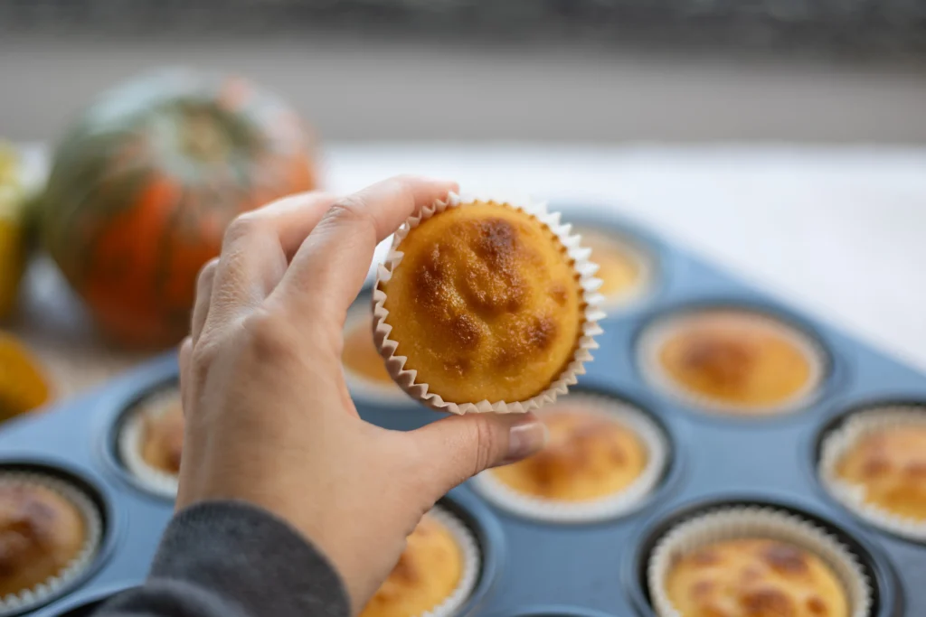 Moist homemade cottage cheese muffins served on a cooling rack with fresh blueberries, perfect for a high-protein breakfast.