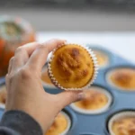 Moist homemade cottage cheese muffins served on a cooling rack with fresh blueberries, perfect for a high-protein breakfast.