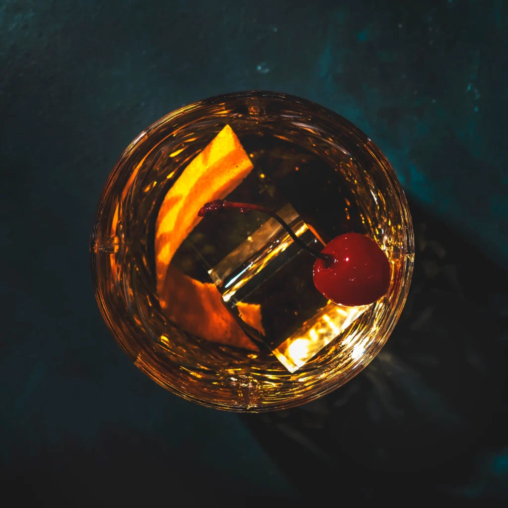 Perfect Classic Old Fashioned Cocktail Recipe with bourbon, orange peel, and ice in a whiskey glass