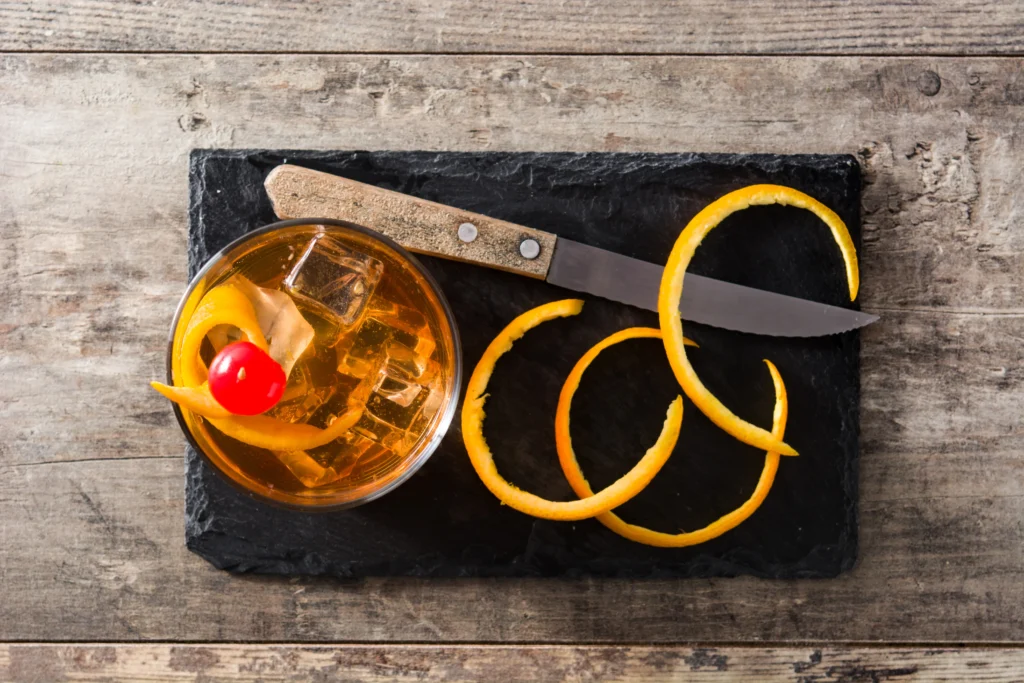 Perfect Classic Old Fashioned Cocktail Recipe with bourbon, orange peel, and ice in a whiskey glass