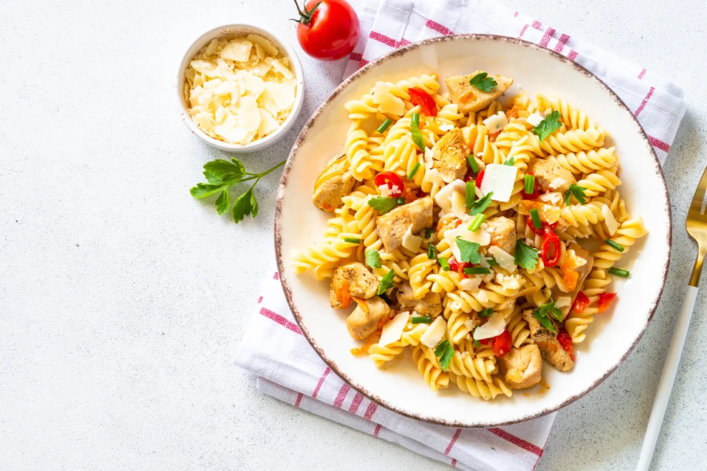 Chicken Caprese Pasta Salad with grilled chicken, fresh mozzarella, cherry tomatoes, basil, pasta, and balsamic glaze served in a rustic bowl.