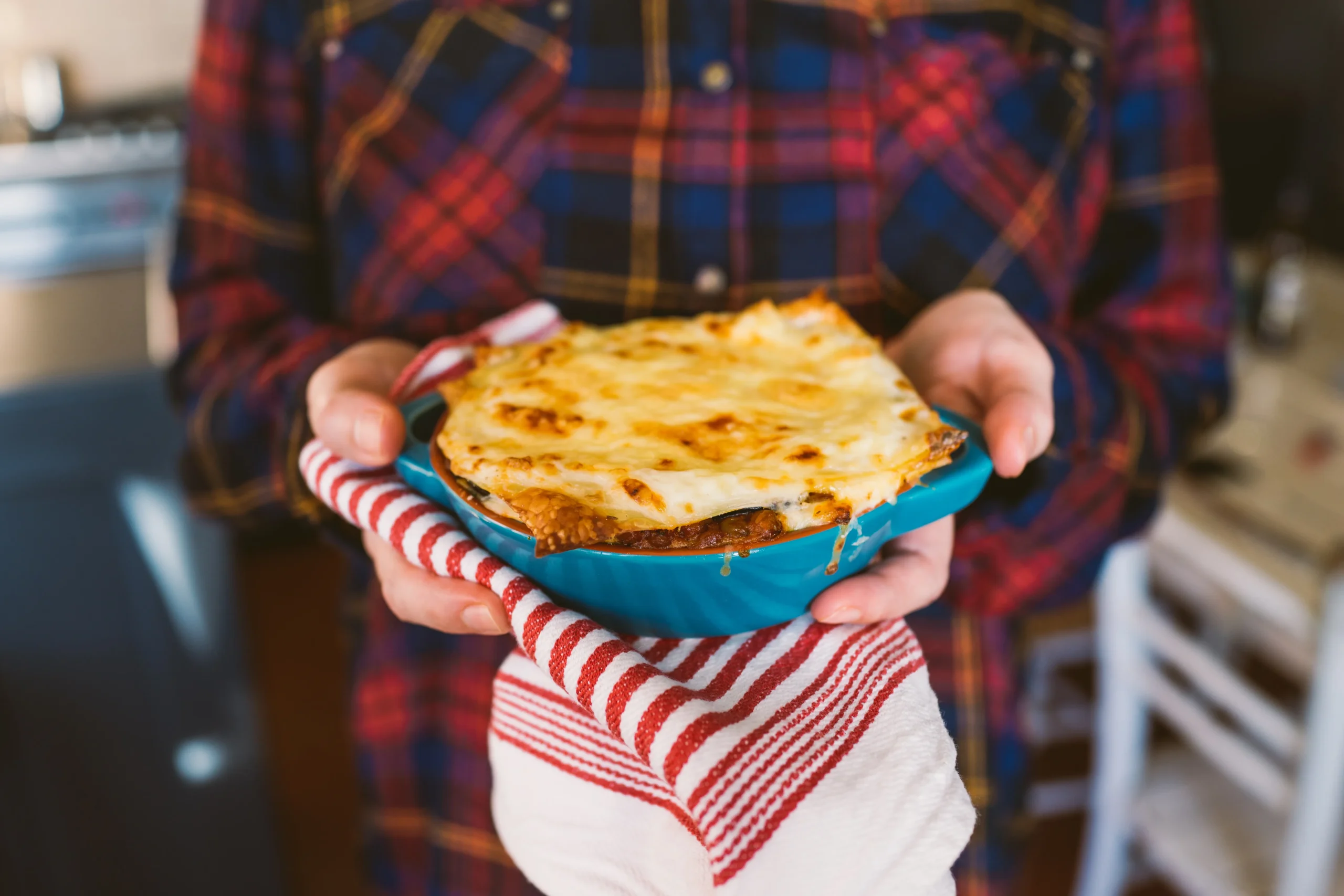 A hearty bowl of lasagna beans topped with melted mozzarella, grated Parmesan, fresh basil, and rich tomato sauce, served with crusty bread.