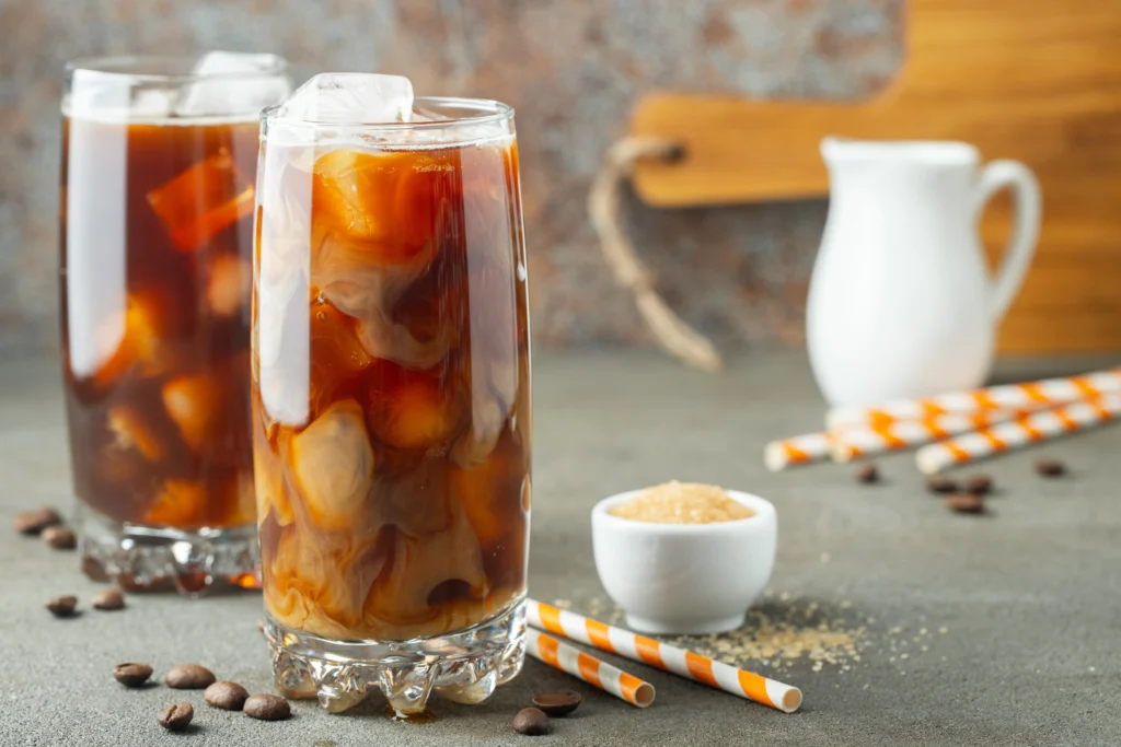Restaurant-quality homemade iced coffee in a glass with ice, milk, and coffee foam