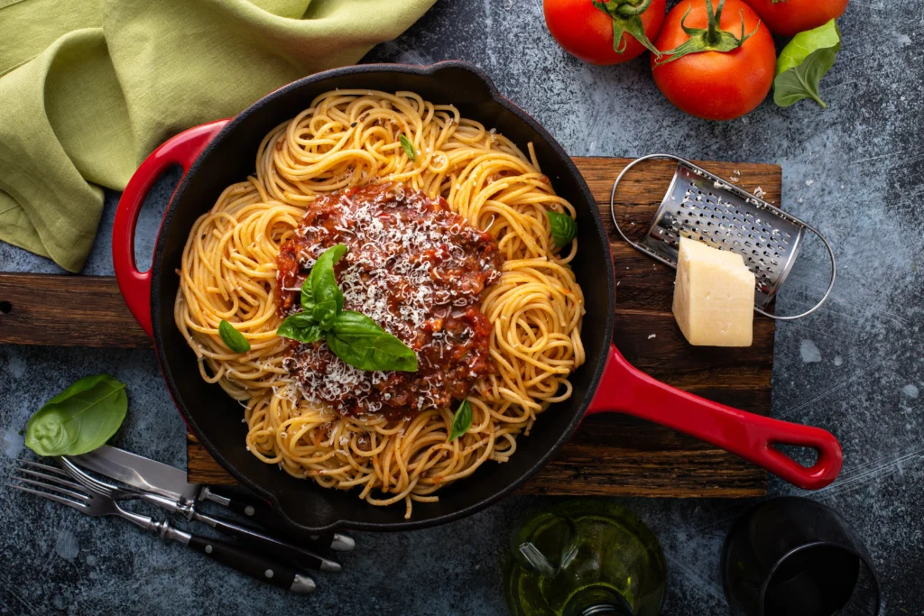 A skillet of dirty spaghetti recipe made with seasoned ground beef, rich tomato sauce, melted cheddar cheese, and perfectly cooked spaghetti, garnished with fresh parsley.