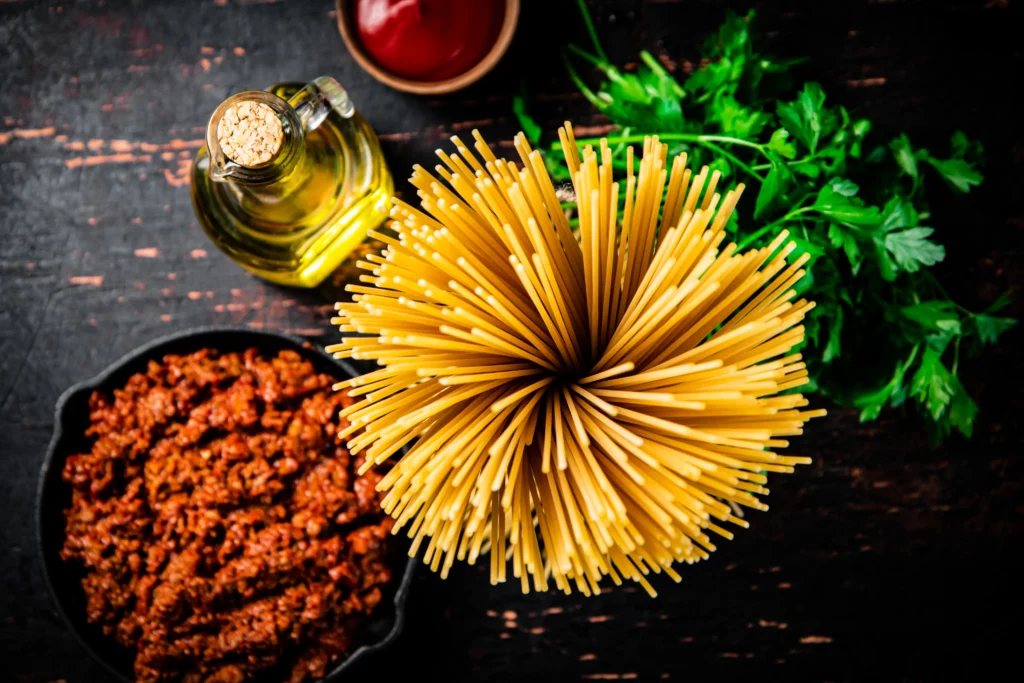A skillet of dirty spaghetti recipe made with seasoned ground beef, rich tomato sauce, melted cheddar cheese, and perfectly cooked spaghetti, garnished with fresh parsley.