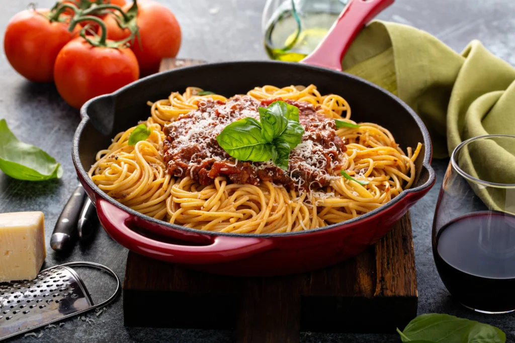 A skillet of dirty spaghetti recipe made with seasoned ground beef, rich tomato sauce, melted cheddar cheese, and perfectly cooked spaghetti, garnished with fresh parsley.