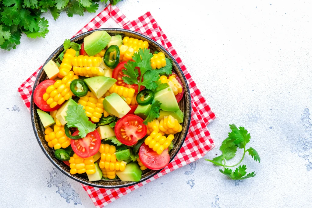 Fresh Summer Corn Salad with tomatoes, avocado, red onion, cilantro, and lime dressing.