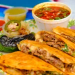 Authentic birria tacos with tender shredded beef, melted cheese, crispy tortillas, and consommé dipping sauce